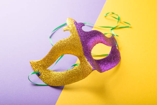 A festive, colorful group of mardi gras or carnivale mask on a yellow purple background. Venetian masks. A festive, colorful group of mardi gras or carnivale mask on a yellow purple background. Venetian masks. gawdy stock pictures, royalty-free photos & images