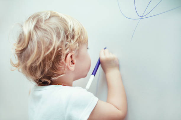istock little boy is drawing the wall 1197683436