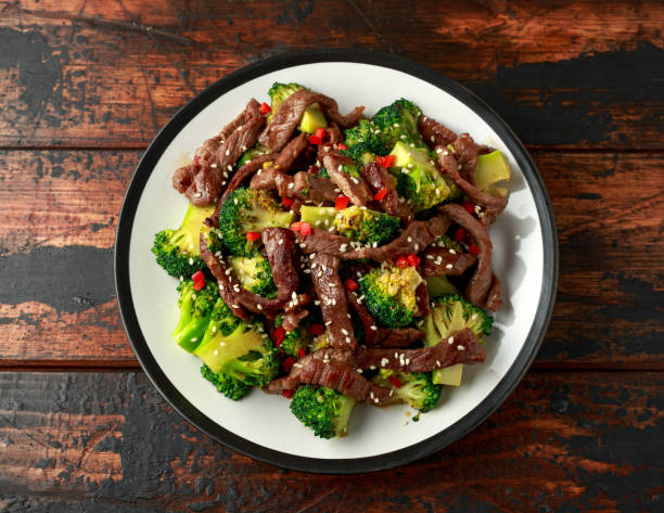 carne casera y brócoli sobre mesa de madera - chopsticks stir fried vegetable beef fotografías e imágenes de stock