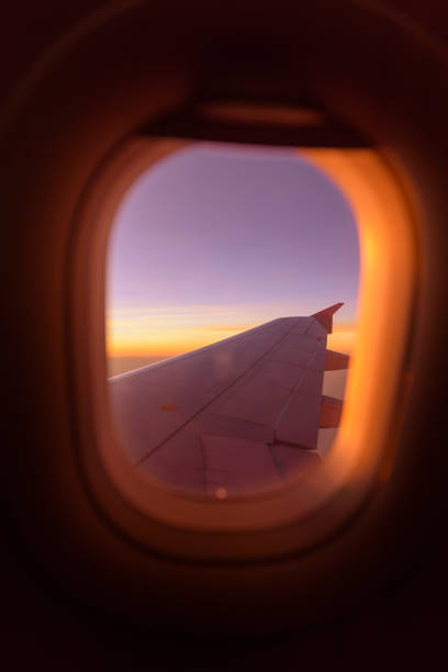 istock plane window ,beautiful sunset on the plane warm tone sunset 1197686843