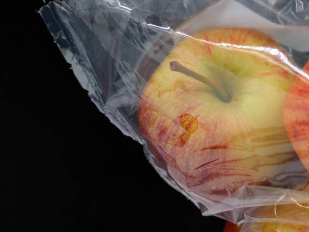 istock red apple in a plastic pocket isolated on black background with copy space 1197689250