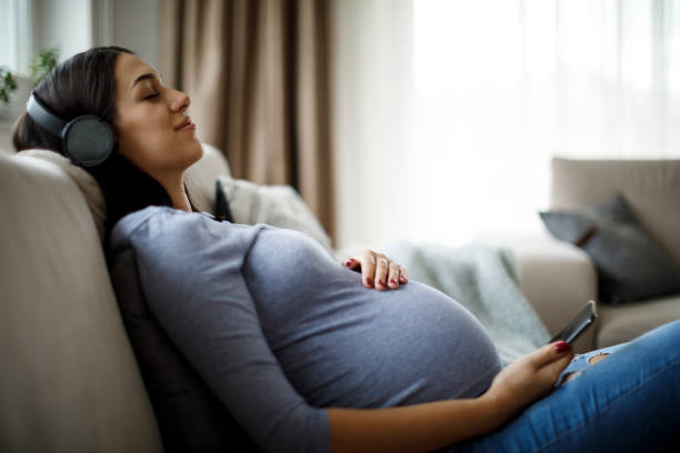 woman enjoying pregnancy - parent mother music listening imagens e fotografias de stock