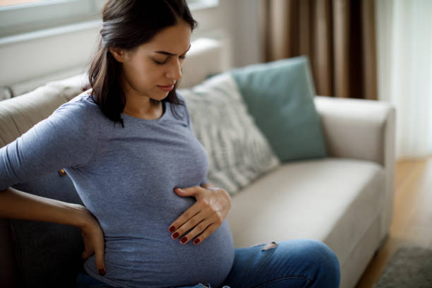 jeune femme enceinte souffrant de maux de dos - uncomfortable photos et images de collection