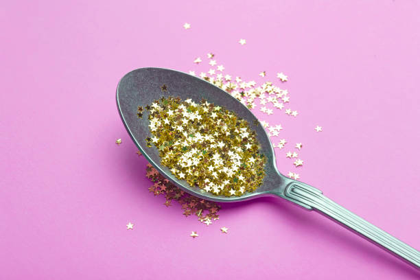istock Gold glitter in a spoon on pink background. Celebration, party, birthday magic background. Creative minimal art concept 1197694701