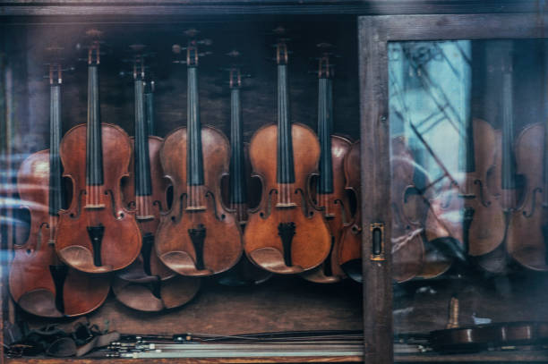 Old and new wooden violins in an old fashioned violin workshop. Vintage, craftsmanship and art