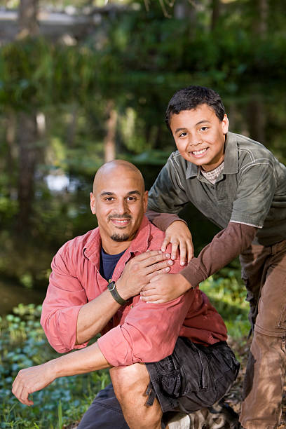 istock Portrait Hispanic father and son outdoors by pond 119770208