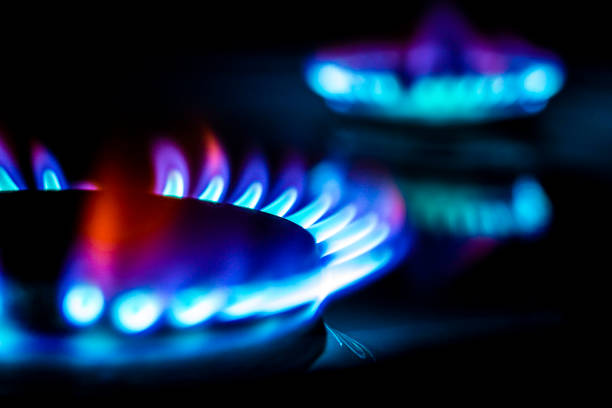 brennende rechnung von hundert dollar auf einem gasbrenner flamme, teures erdgas, die vorderseite und hintergrund sind mit einem bokeh-effekt verwischt - flame gas natural gas blue stock-fotos und bilder