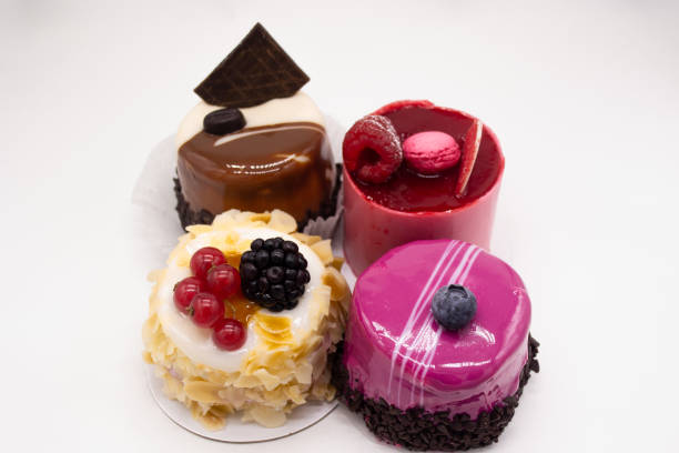 istock Cakes on a white background: Bright red with raspberries, macaroon on top, cream cake with almond petals, red currants and blackberries, coffee cake with piece of chocolate and bright pink glaze 1197703206