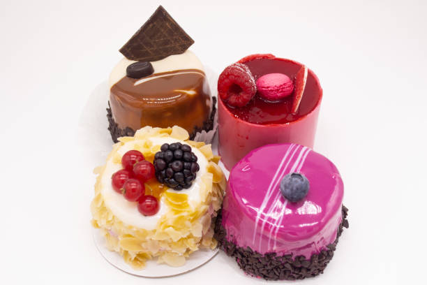 istock Cakes on a white background: Bright red with raspberries, macaroon on top, cream cake with almond petals, red currants and blackberries, coffee cake with piece of chocolate and bright pink glaze 1197703224