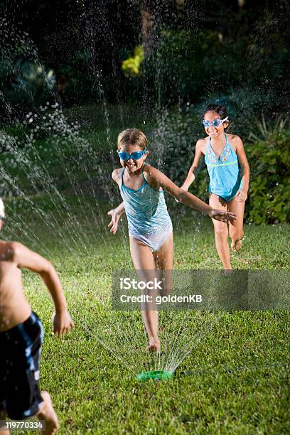 Children Running Through Lawn Sprinkler Stock Photo - Download Image Now - Child, Sprinkler, 6-7 Years