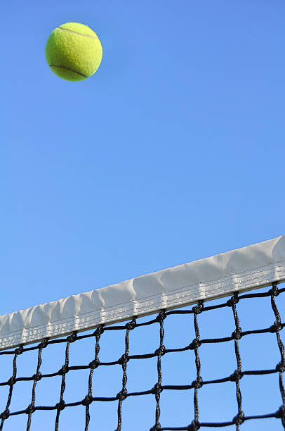 istock Yellow Tennis Ball Flying Over the Net 119770600