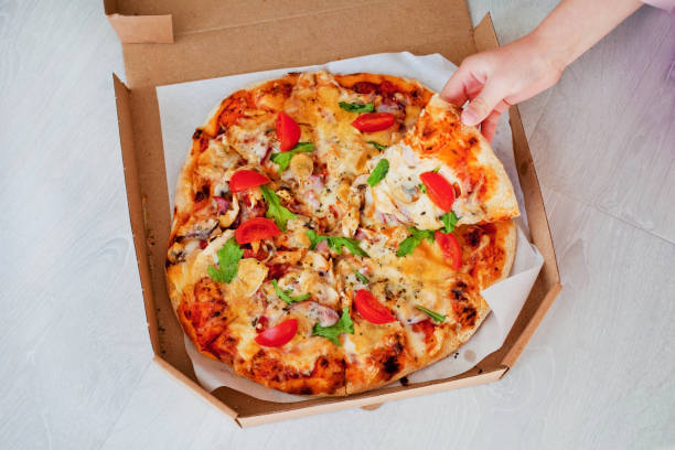 istock People hand with sliced pizza on wooden table closeup 1197706750