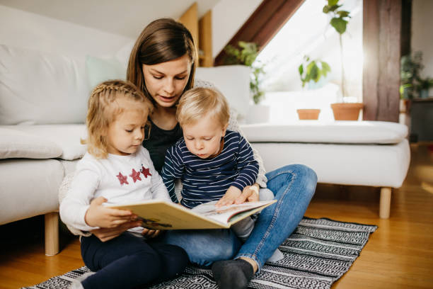 istock Young mother reading a book to her kids 1197712220