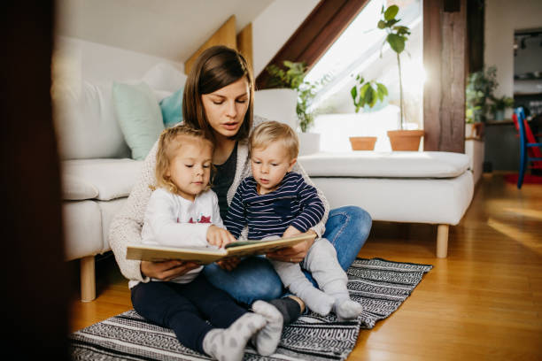 istock Young mother reading a book to her kids 1197712221
