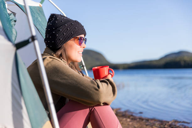 istock Young Women drinking Coffee by the Lake in Camping 1197729086