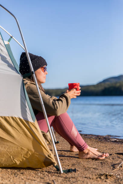 istock Young Women drinking Coffee by the Lake in Camping 1197729145