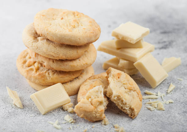 istock White chocolate biscuit cookies with chocolate blocks and curls on light kitchen table background. 1197730074