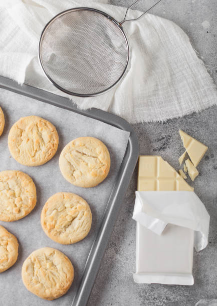 istock White chocolate biscuit cookies on baking tray on light kitchen table background with white chocolate bar. 1197731798