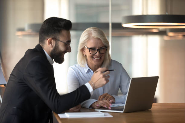 istock Smiling multiracial colleagues brainstorm using laptop at meeting 1197735165