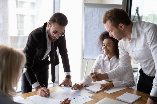 istock Motivated diverse employees brainstorming discussing paperwork at meeting 1197735190