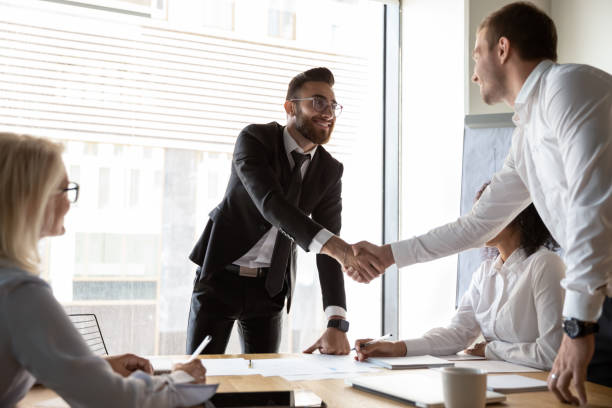 istock Smiling businessmen handshake greeting at team office meeting 1197735199