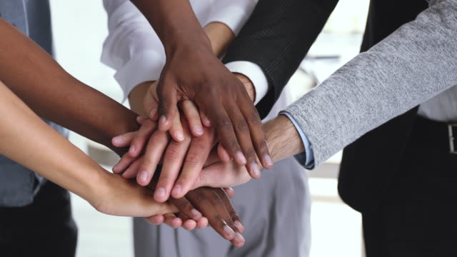Corporate business team people stack hands together in pile, closeup