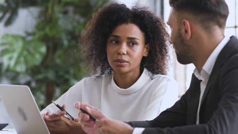 African financial advisor consulting caucasian male client explaining contract benefits