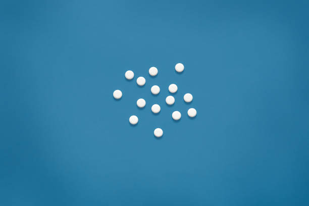 istock Bright blue surface with white tablets. Mock up, white pills on blue background, copy space for special offers as advertising, web background or other ideas. Medical, pharmacy and healthcare concept. 1197737543