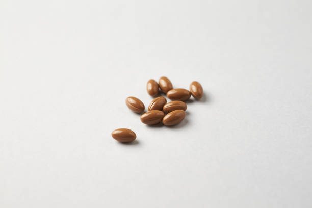 Vitamin K2 tablets on bright paper background. Close up. Copy space.