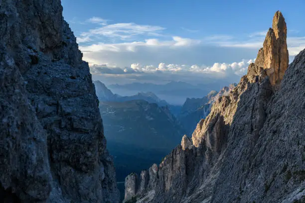 View from the pass Forcella della Neve (2,471 m) of the the Cadini group to the the Monte Piana in the background at sunset. On the right side is the mountain peak Torre del Diavolo visible. It is located in the European Alps, Italy, Dolomites, Province of Belluno.