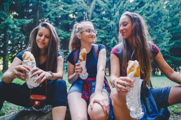 istock Smiling women eating sandwich in forest 1197752050