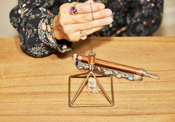 istock A Spiritual Healer using a Crystal Pendulum over a Pyramid 1197753216