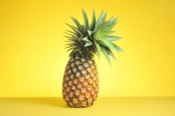 istock Pineapple on bright yellow background. Fresh pineapple on bright yellow background. 1197754272