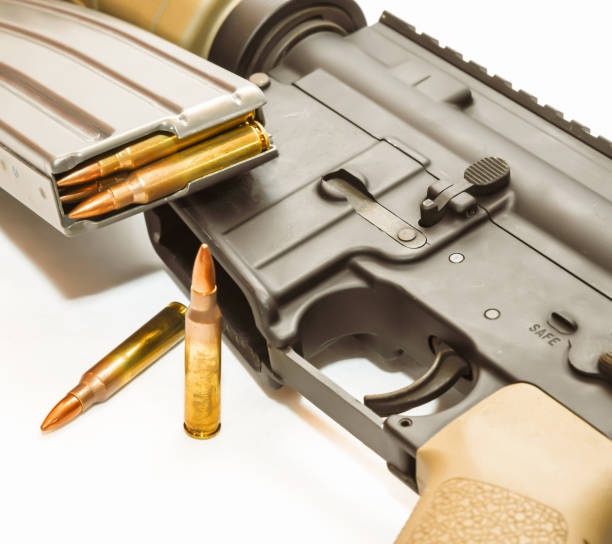 istock An multi colored AR 15 rifle with a rifle magazine loaded with 223 caliber bullets on it with two of the same bullets in front of it 1197754481