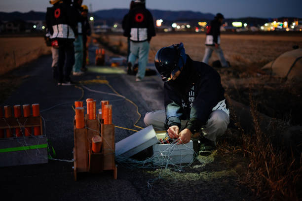 Mid adult man preparing fireworks in preparation for a celebratory event or festival Mid adult man preparing fireworks in preparation for a celebratory event or festival in Japan firework explosive material stock pictures, royalty-free photos & images