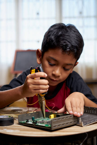 Cute Asian boy learning electronic hardware stock photo
