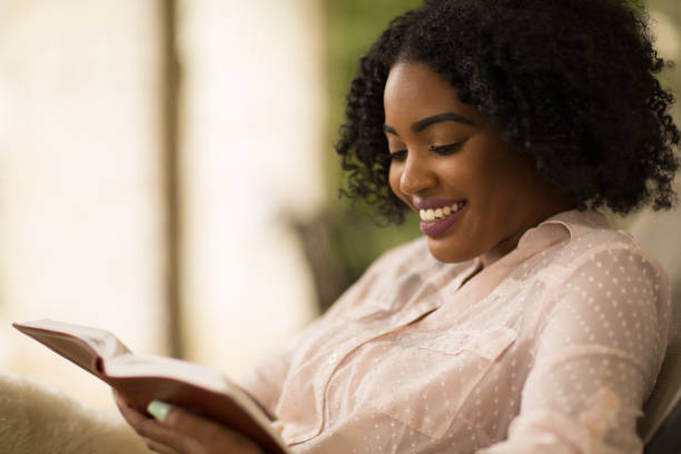 istock Woman smiling holding a book. 1197774175