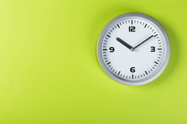 istock minimalistic white wall clock with light metal on a green background. time concept. 1197781703
