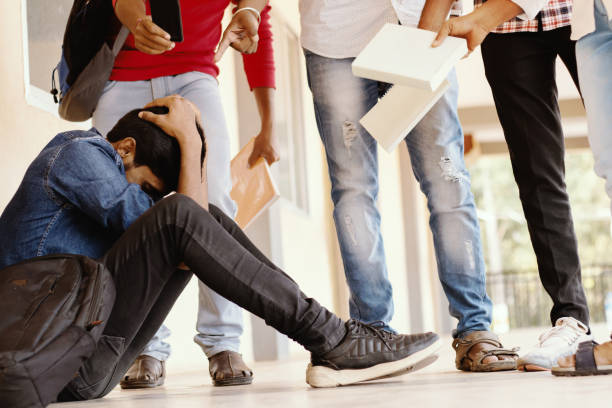 teenage boy being bullied at school, se cubrió la cara - grupo de estudiantes que amenazan con golpear a su compañero de clase o junior en la universidad - concepto de burlas, toros o advertencia en el campus universitario. - haciendo burla fotografías e imágenes de stock