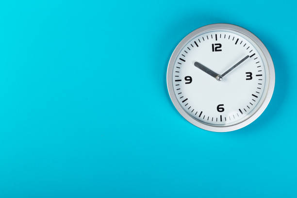 istock minimalistic white wall clock with light metal on a blue background. time concept. 1197781737