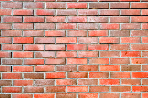Old red brick wall grunge texture. Old cracked bricks wall with a weathered surface. Brick wall background, copy space for design and text. Vintage brick wall. Empty wall. Brown brickwork texture