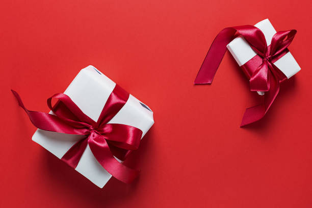 istock Two white gift boxes on a red background. Valentine's day. Holiday of lovers. 1197794151