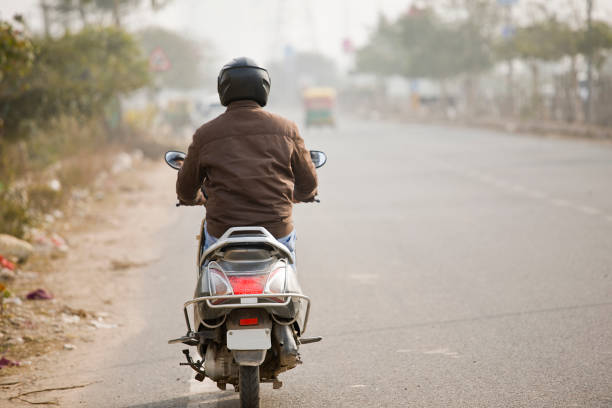 Man riding motor scooter on city street