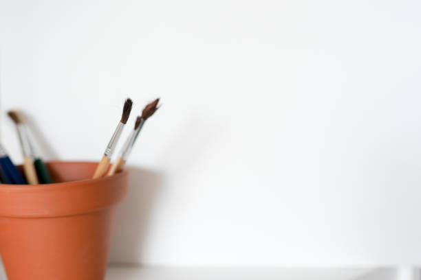 istock A pot of artists paint brushes in a browm pot on a white background. Copy space available. 1197799116