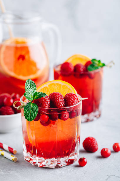 framboise cranberry sangria punch ou mojito en verre avec des tranches d'orange et de menthe - raspberry soda photos et images de collection