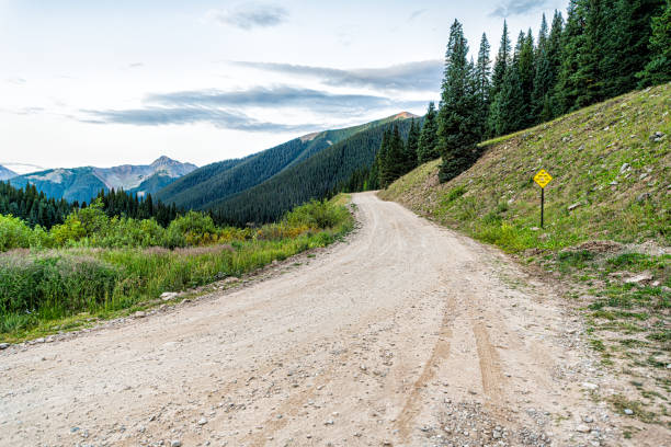 vista grande do ângulo de montanhas alpinas verdes com estrada de terra que conduz à passagem de ophir perto da fuga do lago columbine em silverton, colorado na manhã de verão 2019 - hiking mountain dirt scenics - fotografias e filmes do acervo