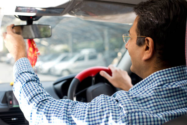 istock Man adjusting the rear view mirror of car 1197802431
