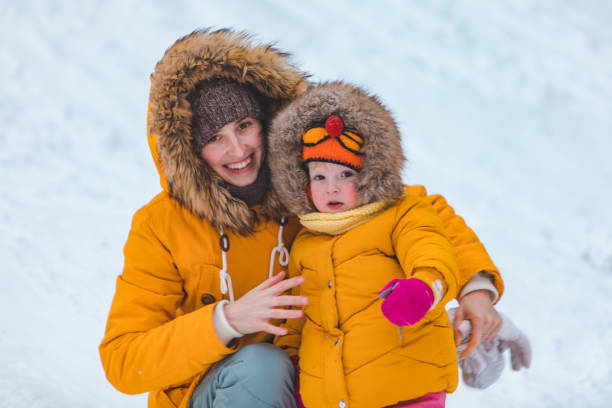 istock mother with daughter sliding from winter hill 1197802609