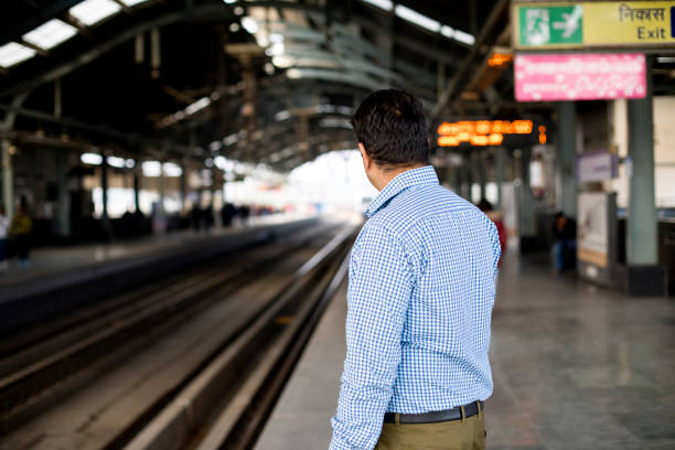 Man waiting for train at railroad station platform