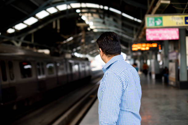 Man waiting for train at railroad station platform